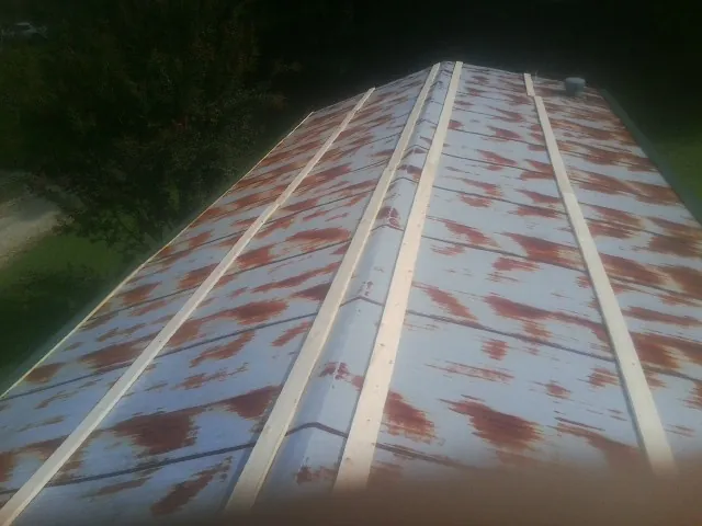 Rusted metal roof panels with new wood purlins before replacement — Storm Damage Roof Repair in Anita by Roofing Brothers