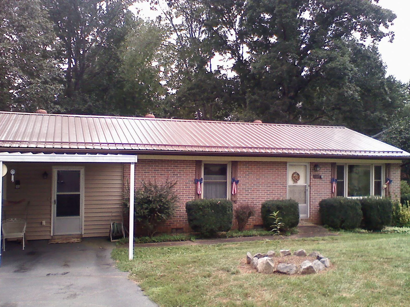 Bronze metal roof and carport on a brick ranch home — Roof Repair work by our crew in Anita