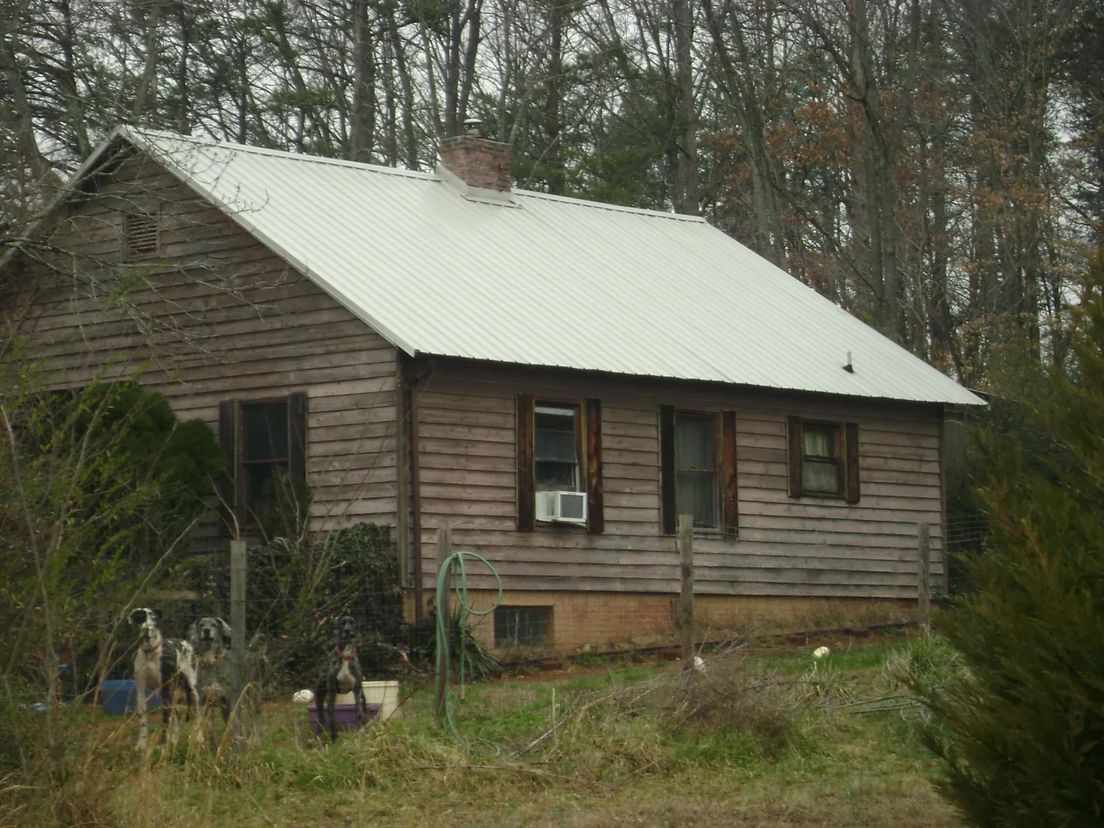 White metal roof on an old wood sided farmhouse, from a Metal Roof Installation job in Anita